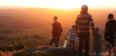 : Eine Gruppe Longboarder am Hang im Abendlicht