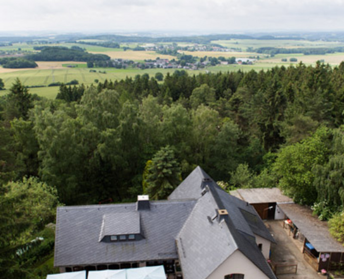 Blick vom Kuhberg-Turm auf die Kuhbergbaude und die dahinter liegenden Felder