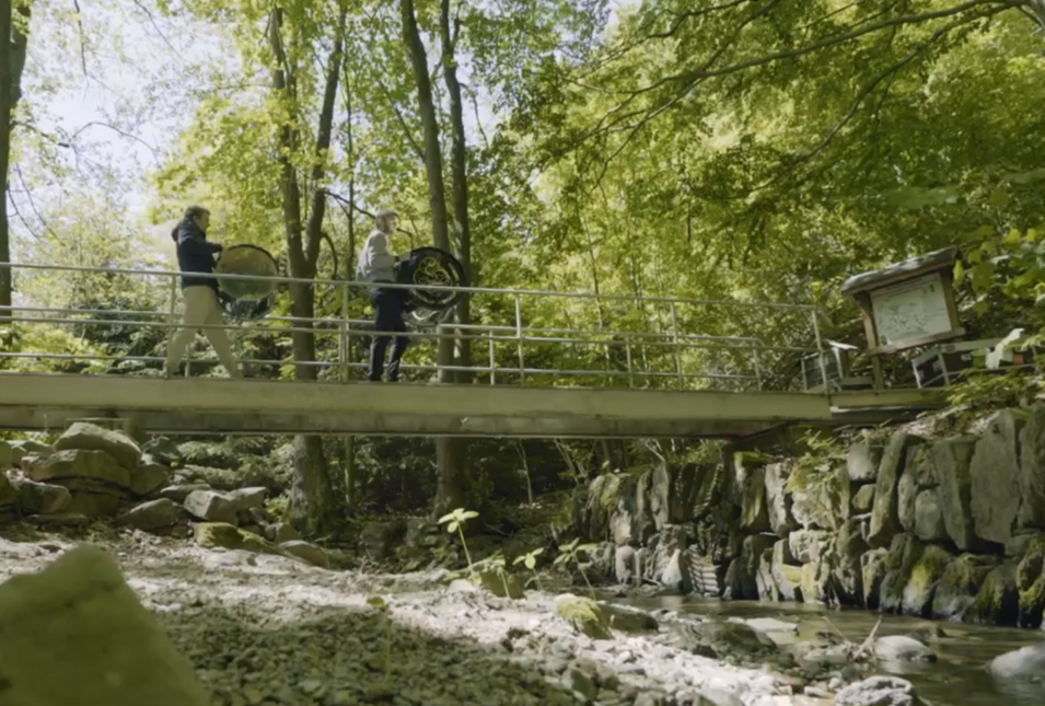 zwei Musiker überqueren eine Brücke in der Natur