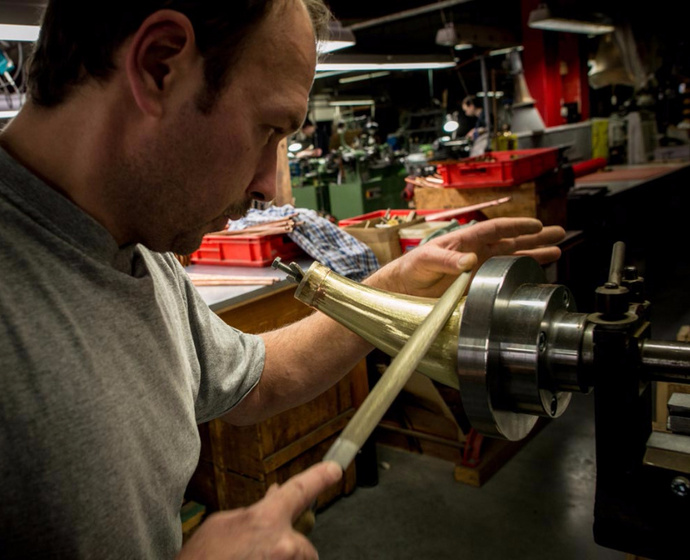 Handwerker beim Schleifen eines Blechblasinstruments