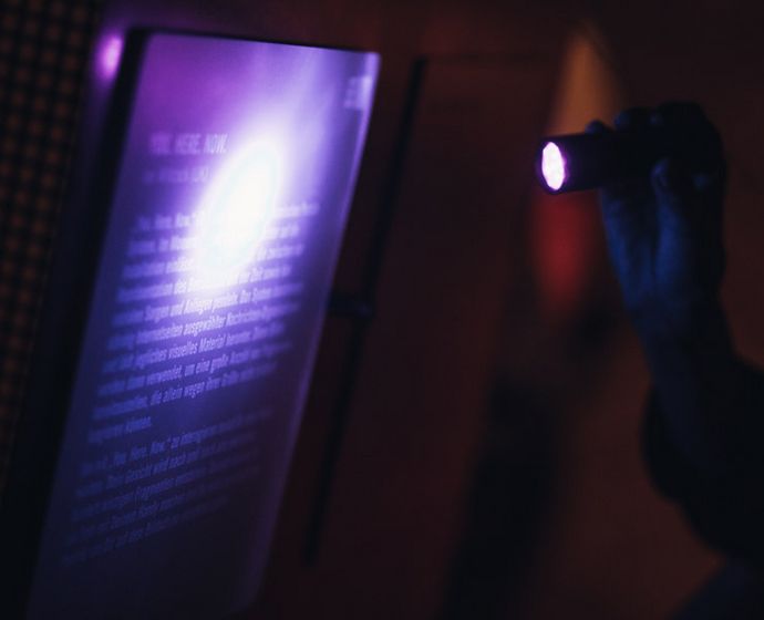 Besucher leuchtet mit Taschenlampe auf Exponat