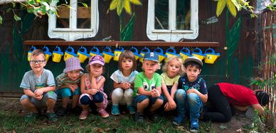 Kinder hocken vorm Kindergarten in Nebelschütz.