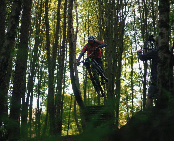 Biker im Wald beim Sprung