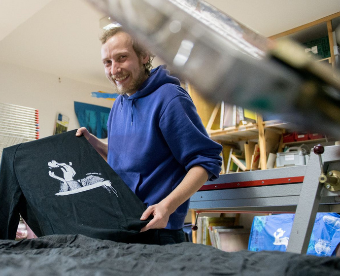 Mann mit bedrucktem Pullover aus der Siebdruckwerkstatt