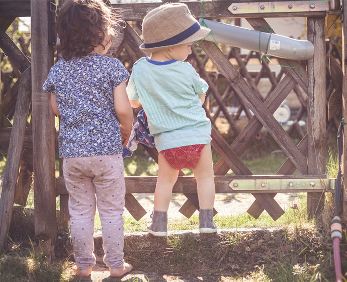 Zwei Kinder am Gartenzaun 