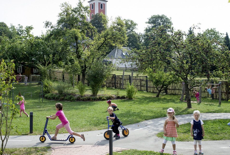 Kinder spielen auf einer Wiese im Kindergarten.