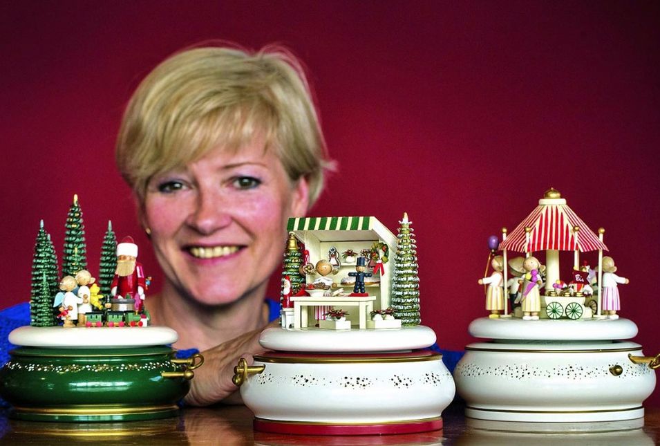 Katrin Flade-Drechsel mit drei Spieluhren voller gedrechselter Figuren