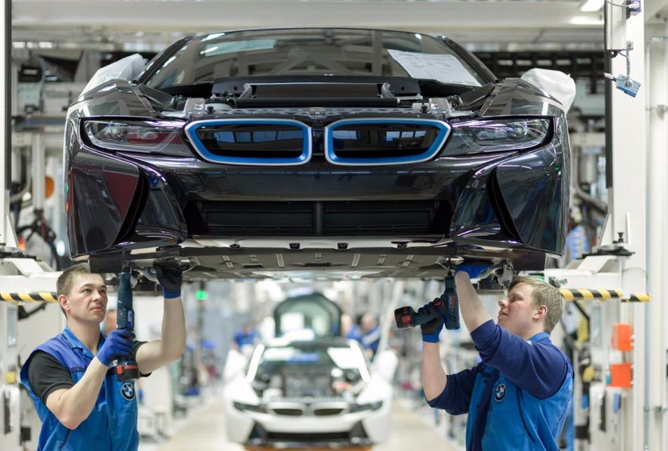 : Techniker schrauben den Unterboden eines BMW-i-Modells zusammen 