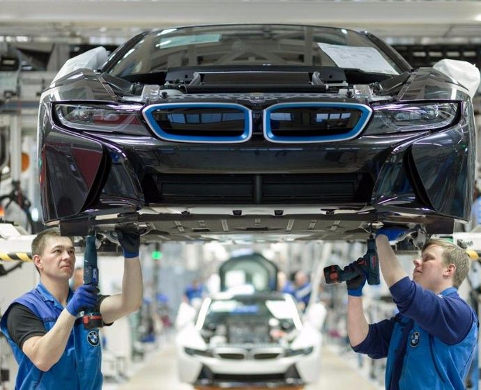 Techniker schrauben den Unterboden eines BMW-i-Modells zusammen 