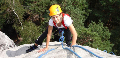 Schülerin klettert am Felsen