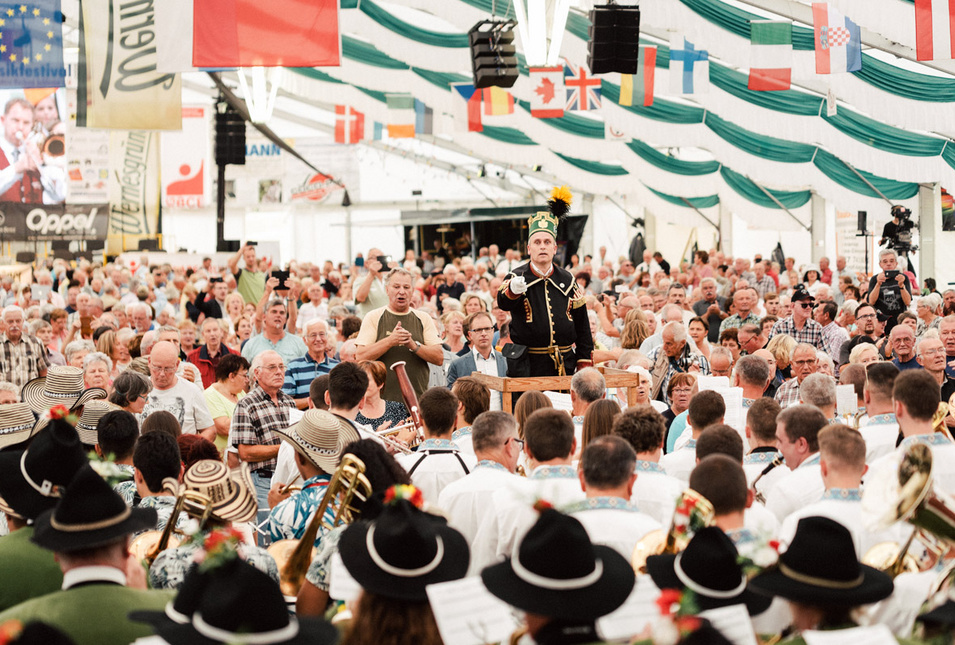 Dirigent zwischen Musikern und Publikum.