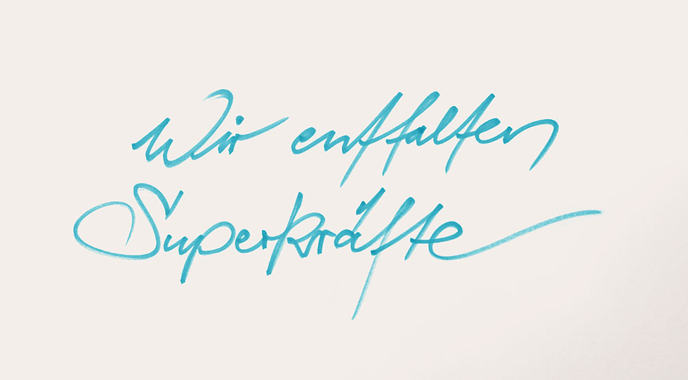 "Wir entfalten Superkräfte" -Schriftzug auf einem Blatt Papier