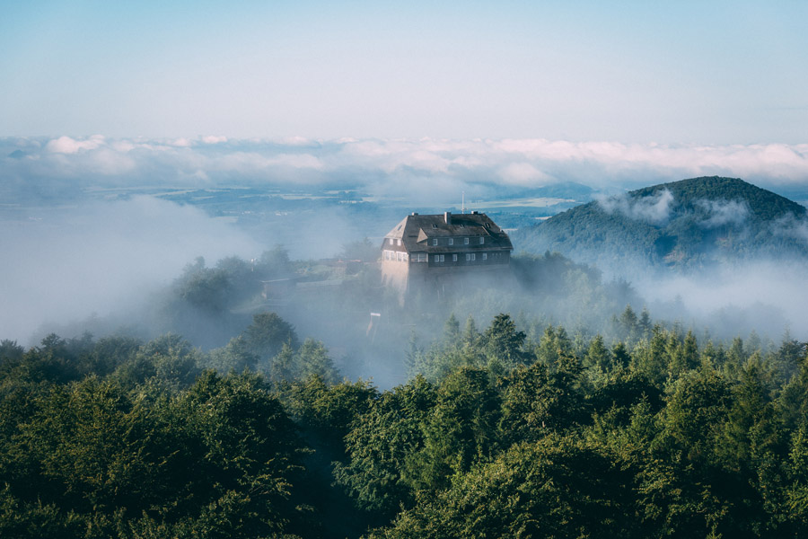 Verlassenes Haus auf einem Hügel zwischen Wolken